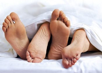 Close up of the feet of a couple on the bed